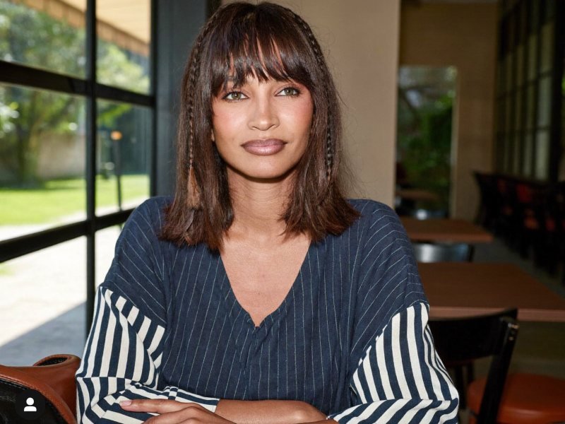 Bob haircuts: a woman with a chin-length French bob and soft bangs in natural light