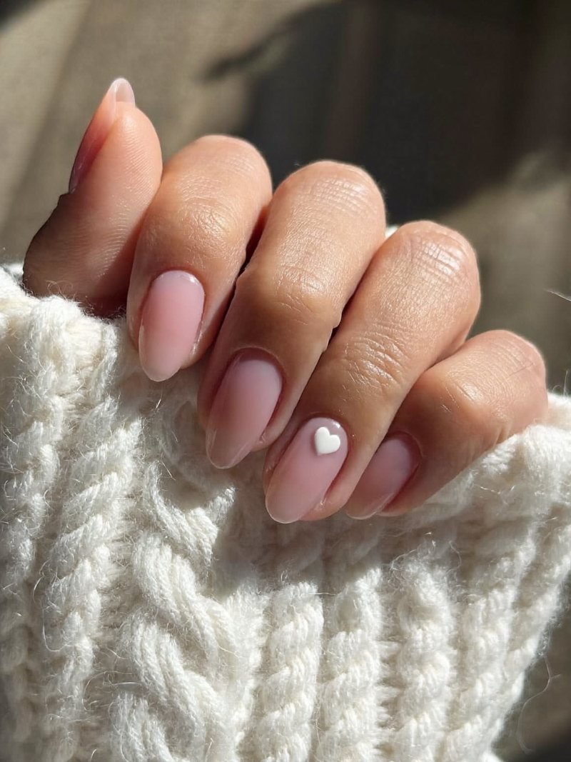 Cute nail designs: short pink nails with a tiny white heart on the ring finger