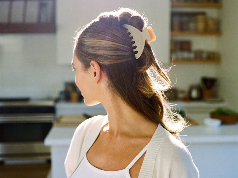 Easy hairstyles for long hair: a woman with her long hair twisted up in a claw clip