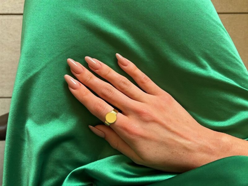 Gold accent nude nails for a green dress in emerald satin