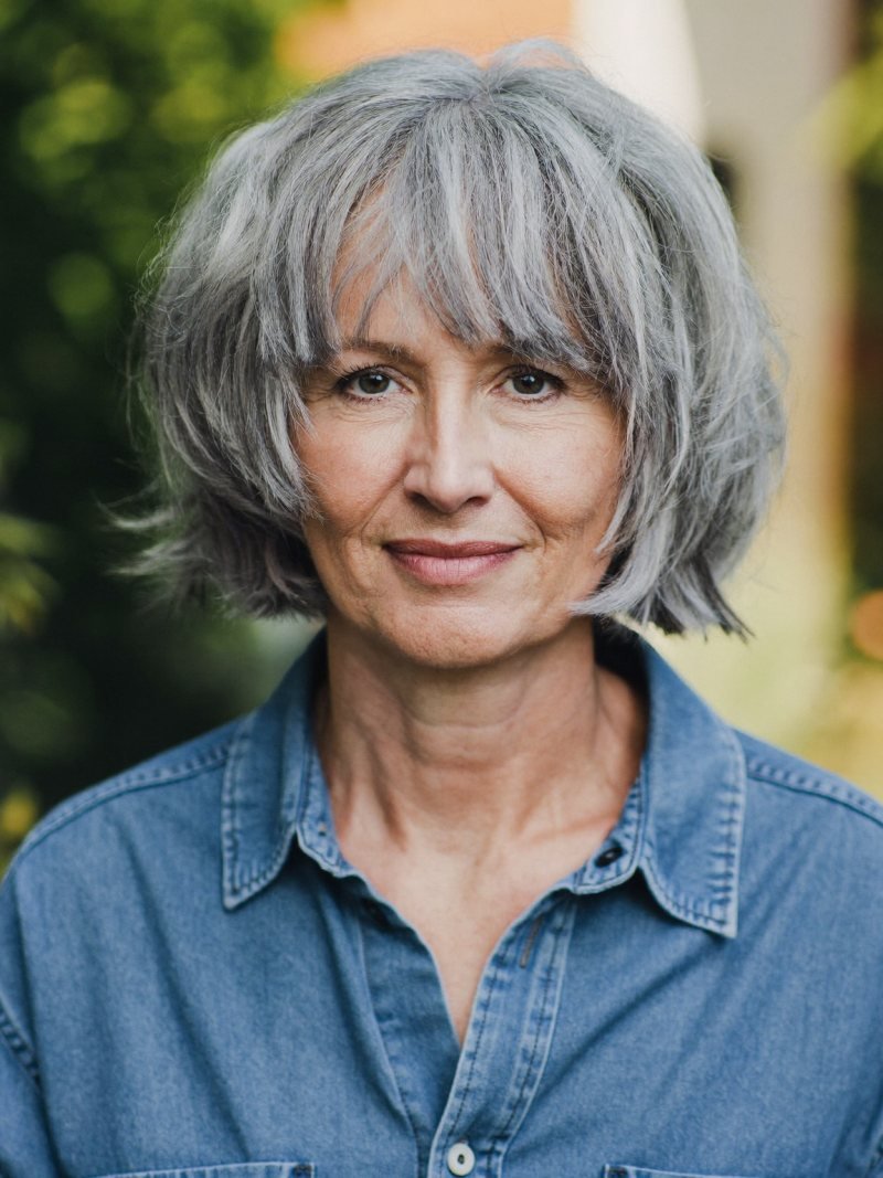 Jaw-length salt and pepper shaggy bob with choppy layers and wispy bangs