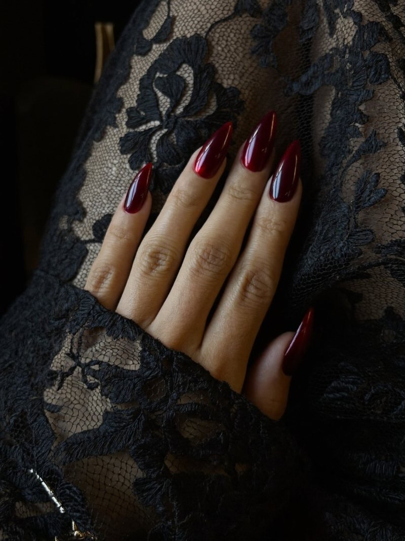 Long almond nails in dark red chrome with a mirror shine
