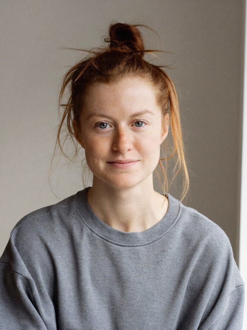 Long auburn hair in a loose messy top knot