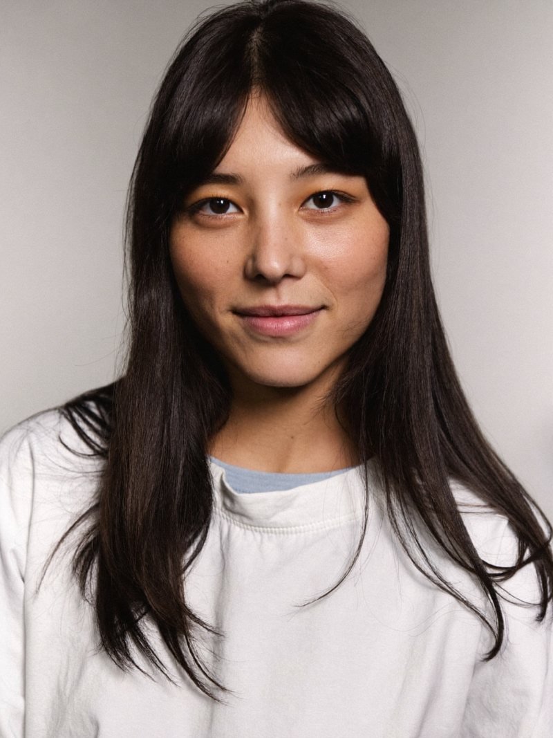Long black hair with classic curtain bangs parted in the center