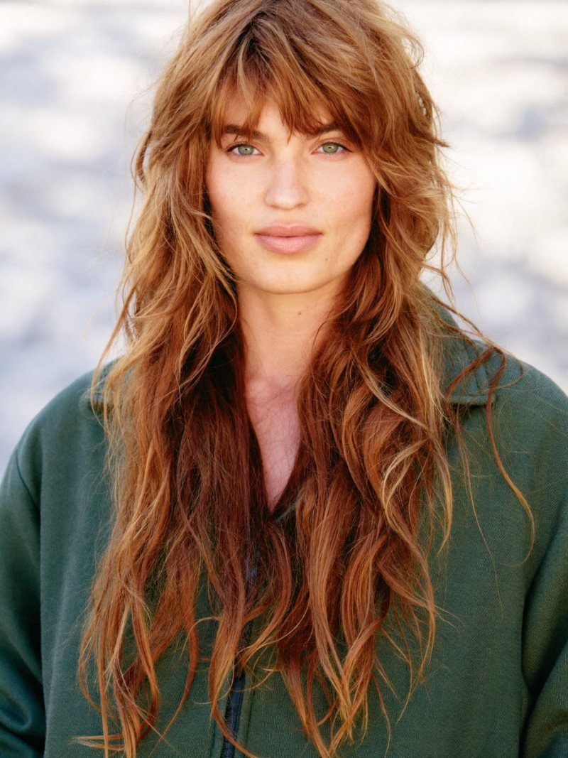 Long copper hair in a wolf cut with choppy top layers