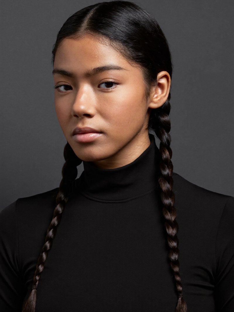 Long dark hair in two sleek low braids with a center part