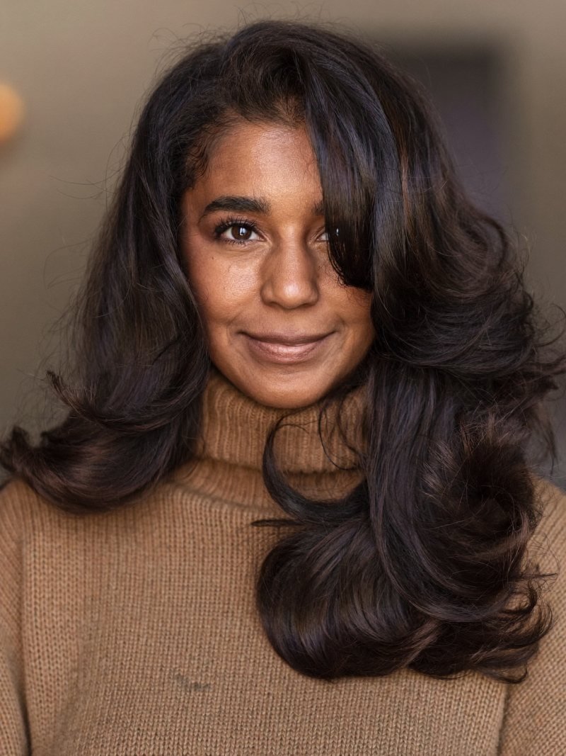 Long dark hair with rounded layers styled in a bouncy blowout