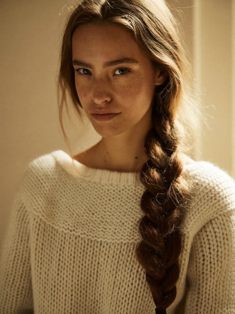 Long hair in a loose low braid over one shoulder