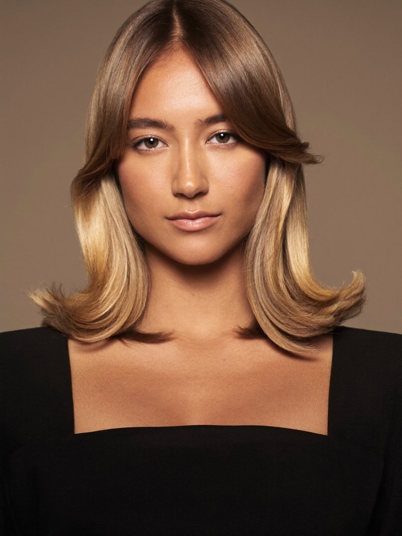 Long straight dark blonde hair with smooth flat-ironed curtain bangs