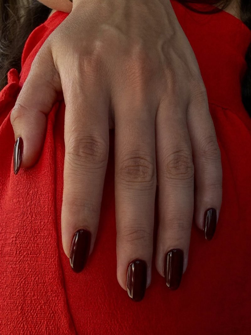 Medium almond burgundy nails with a red dress