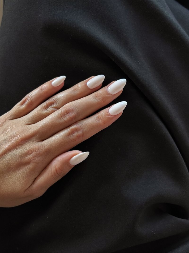 Medium almond milky white nails with a black dress
