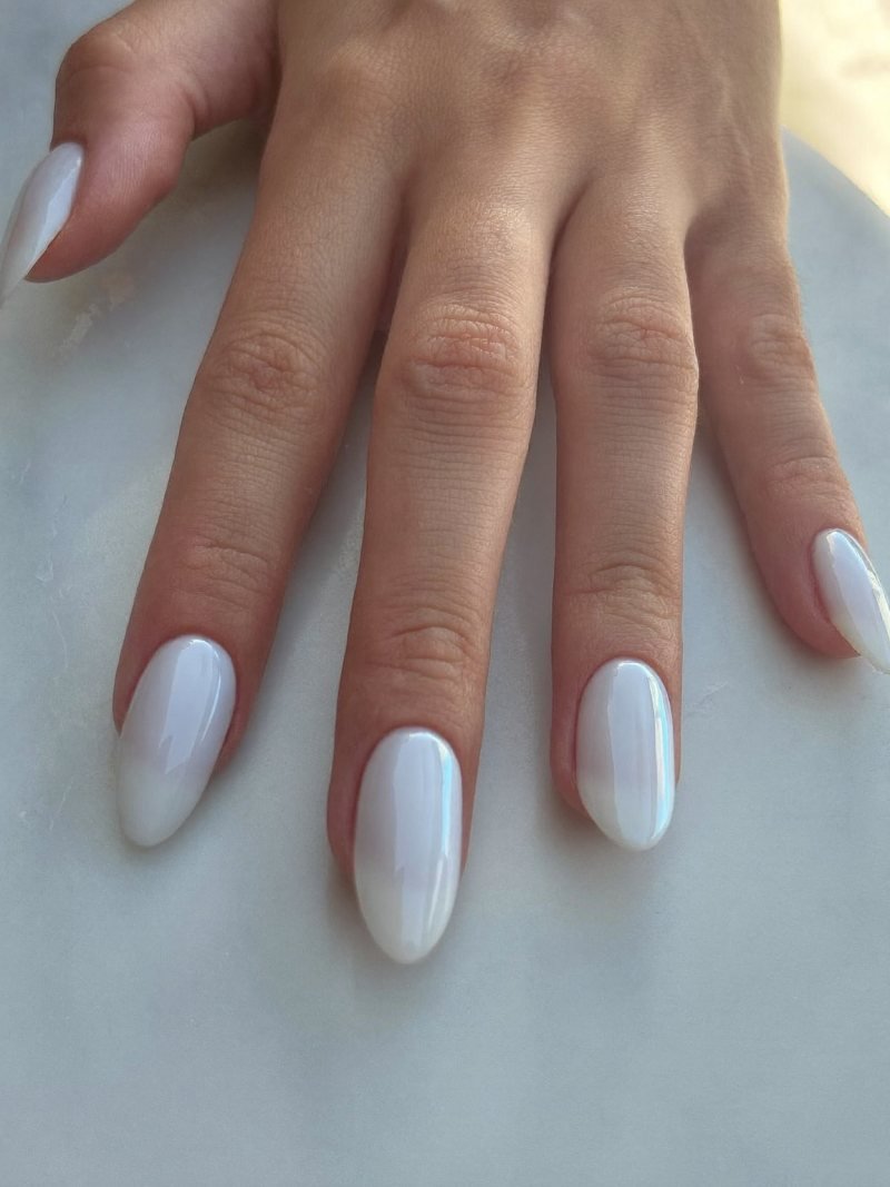 Medium almond milky white nails with a pearly chrome glaze