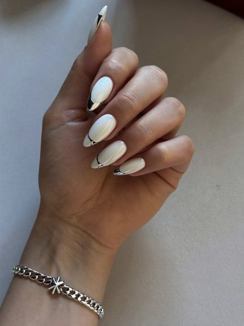 Medium almond milky white nails with thin silver chrome tips