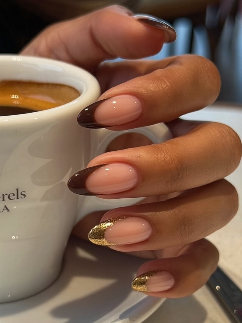 Medium almond nude nails with chocolate French tips and a gold glitter line beneath