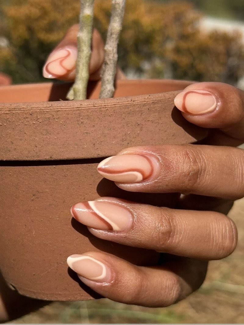 Medium almond nude nails with terracotta and cream swirls