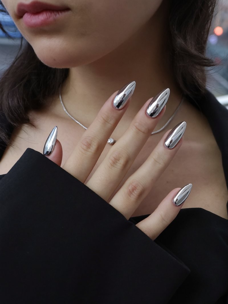 Medium almond silver chrome nails with a black dress