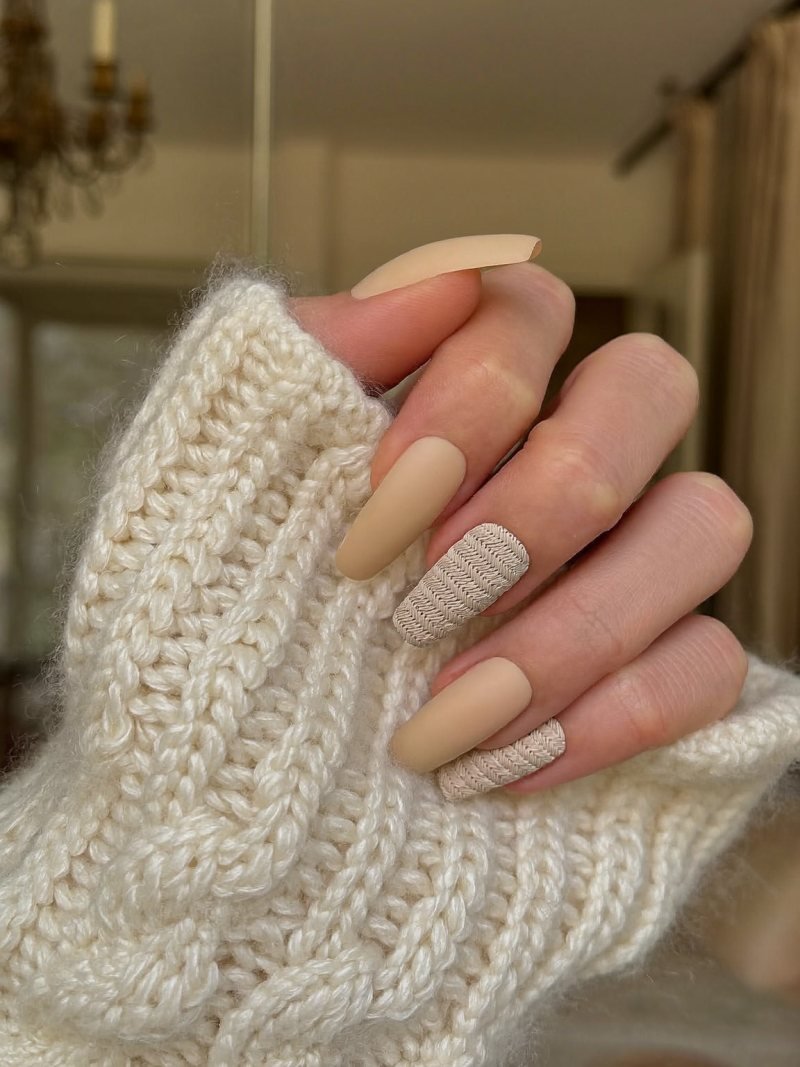 Medium coffin matte nude nails with raised cable knit lines on two fingers