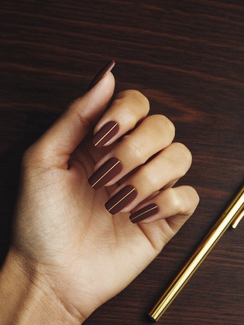 Medium square matte cocoa brown nails with one vertical gold stripe