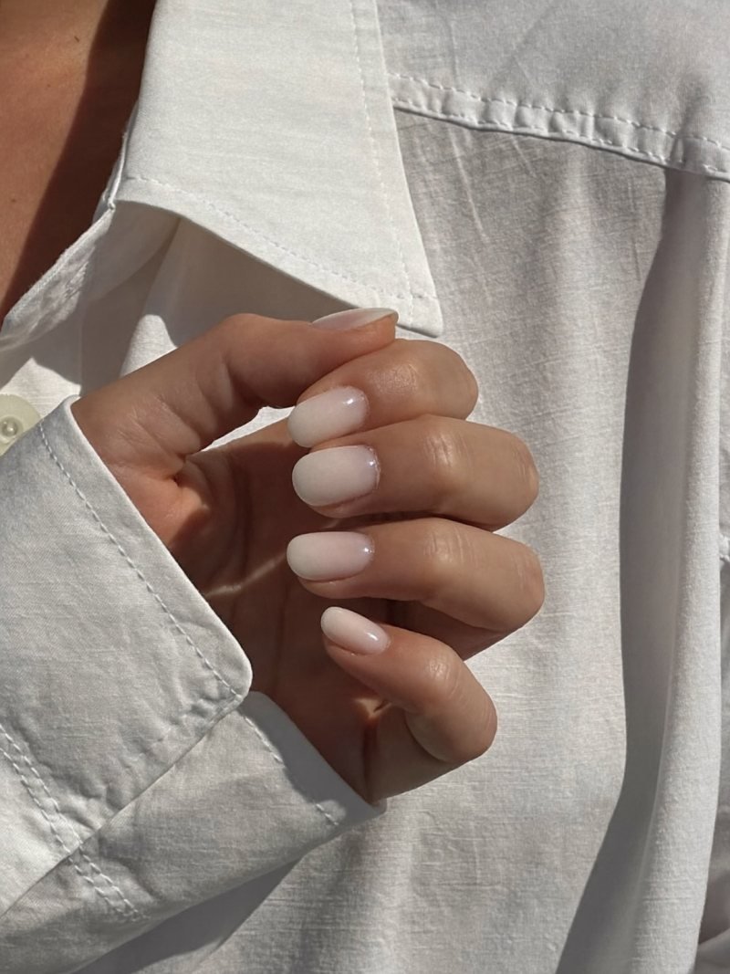 Milky white nails on short round nails with a glossy finish