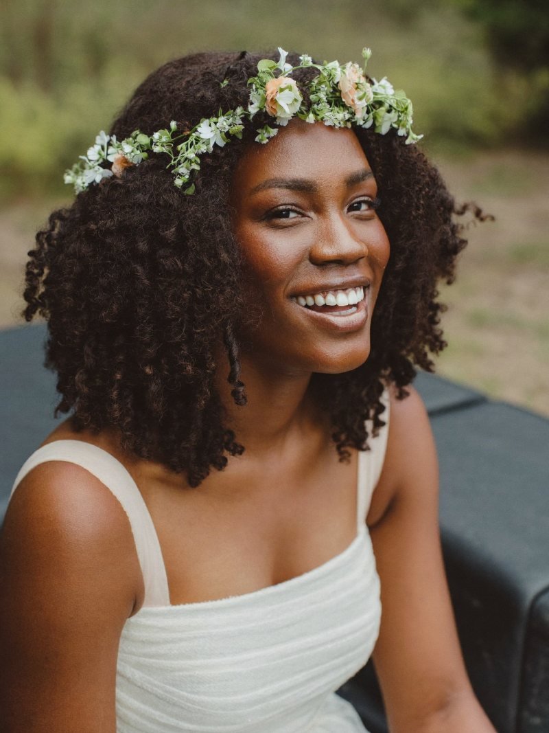Natural curls worn out with a ring of small fresh flowers