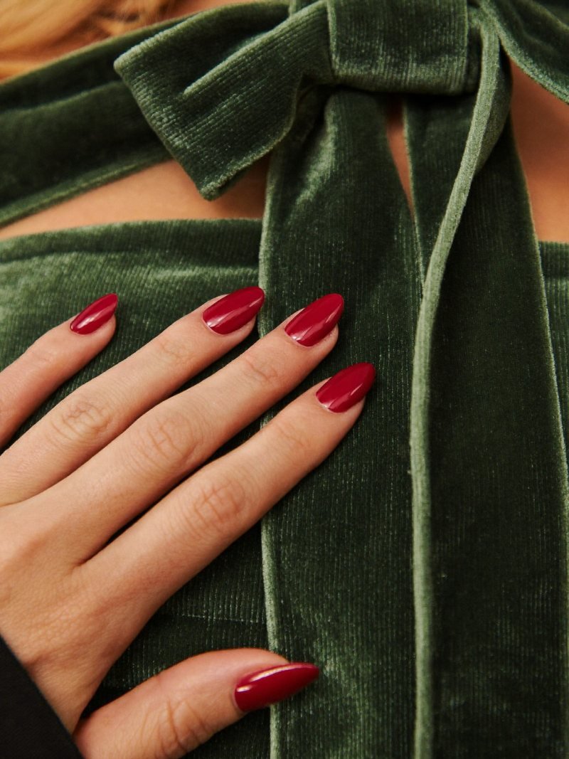 Short almond Christmas nails in glossy cranberry red
