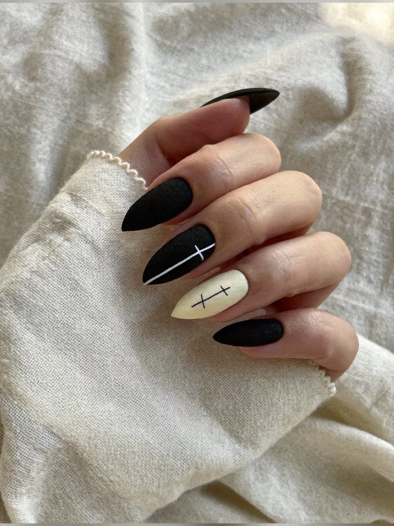 Short almond matte black nails with thin white stitch marks on two fingers