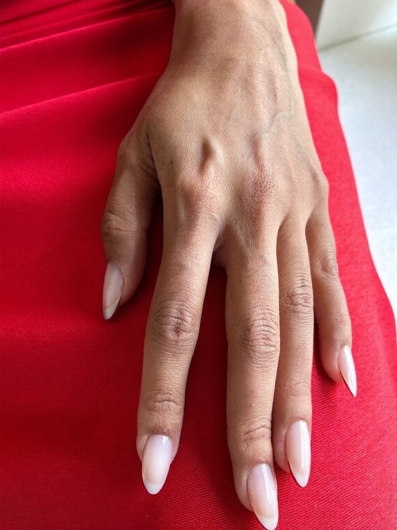 Short almond nude nails with thin red French tips
