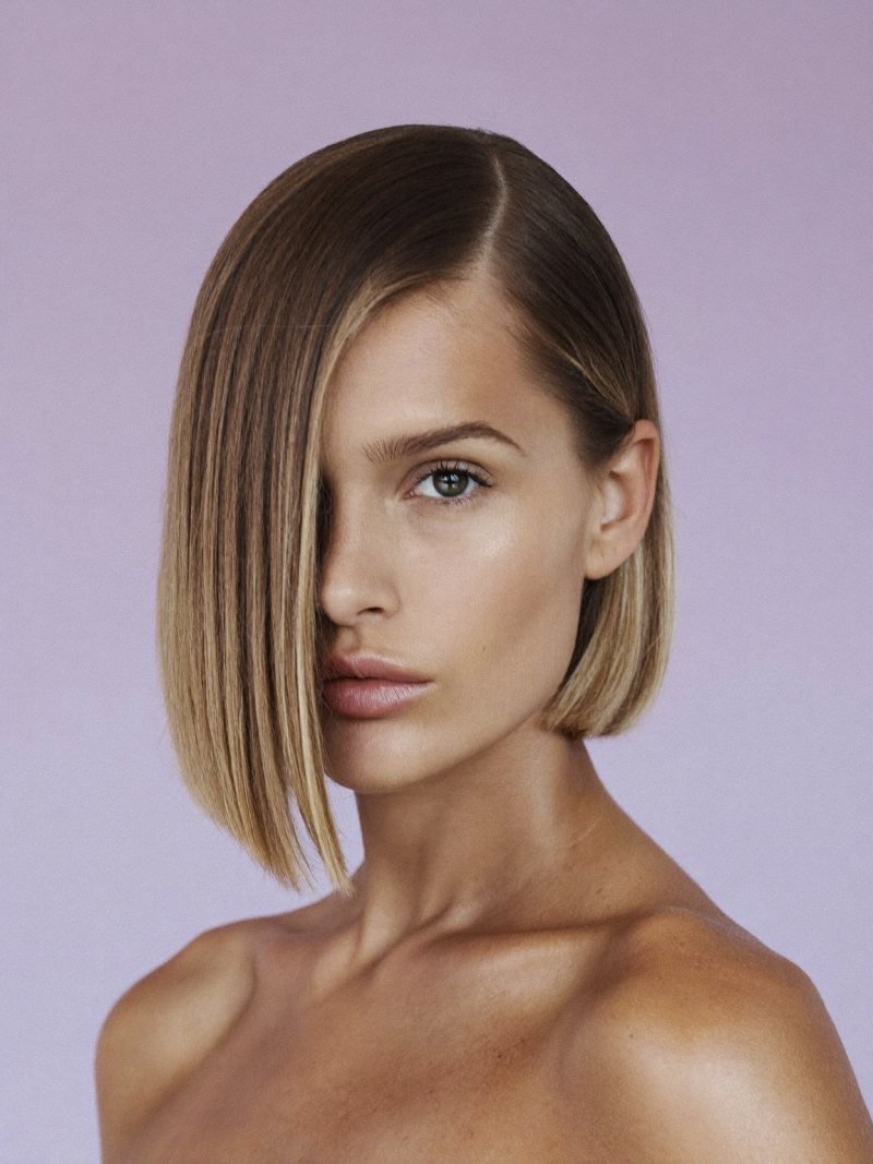 Short bob with a deep side part tucked behind one ear