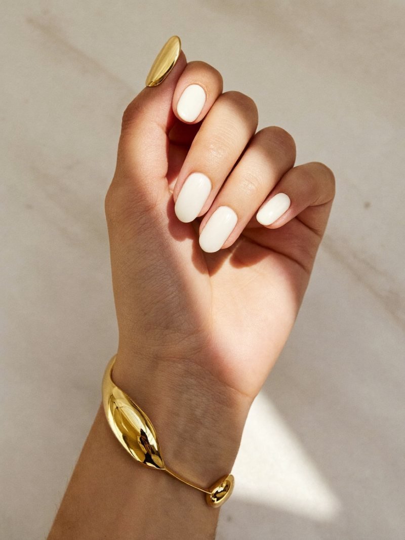 Short oval milky nails with one gold chrome accent nail