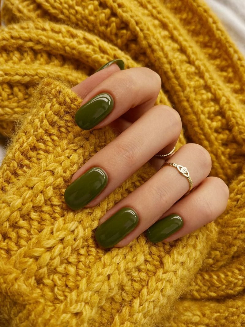 Short oval nails in olive green with one gold accent nail
