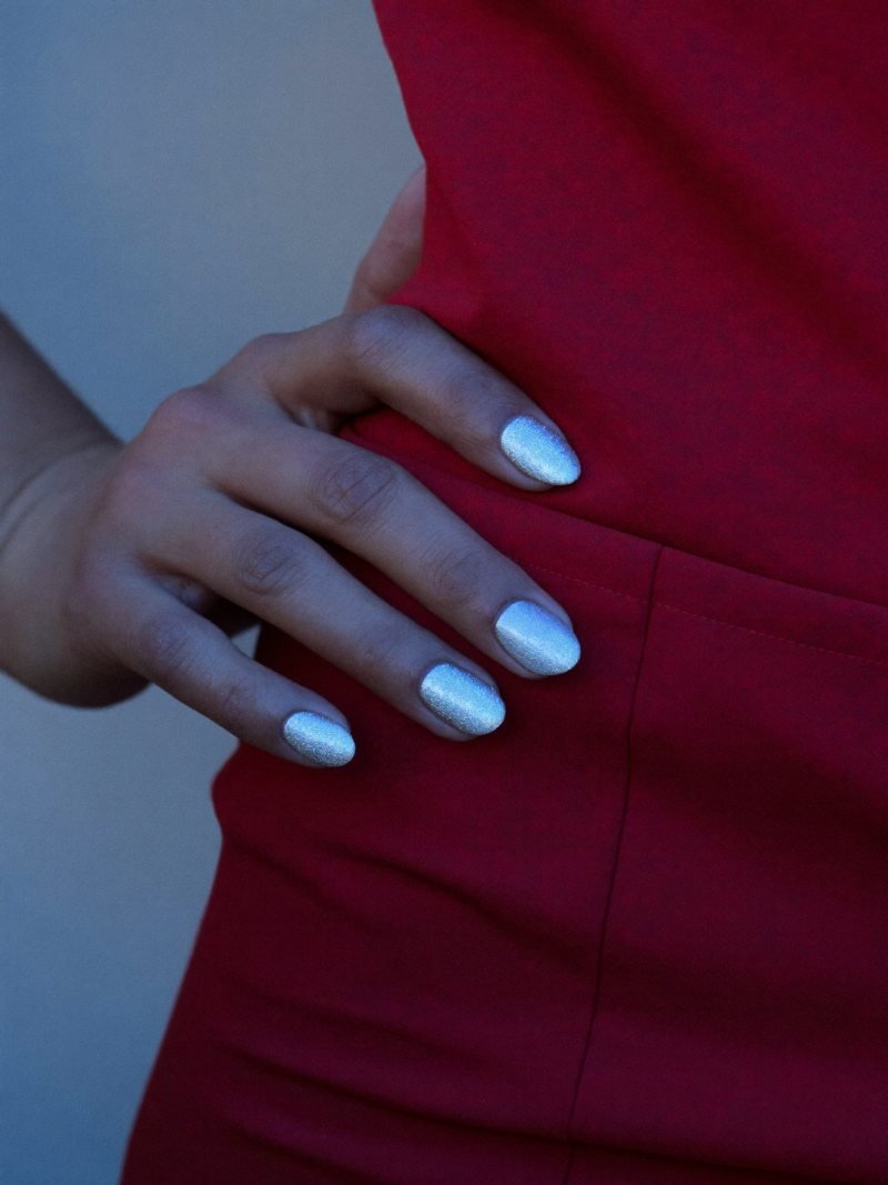 Short oval silver shimmer nails with a cool red dress