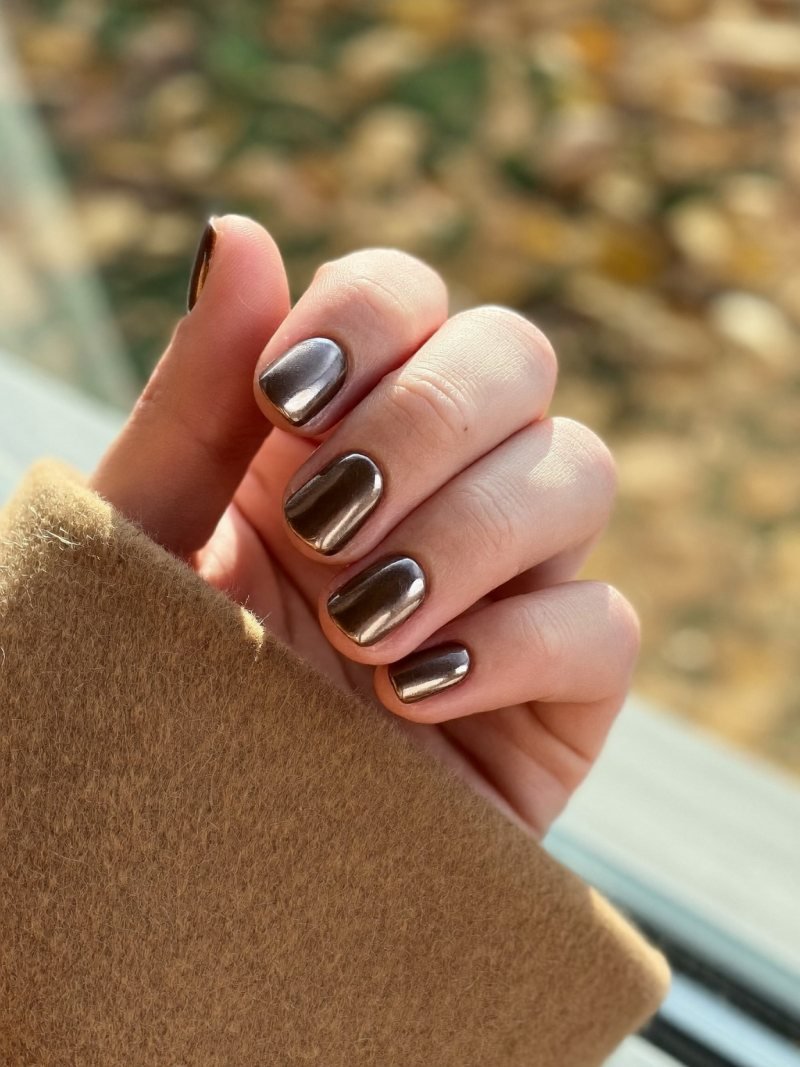 Short round brown nails with a chrome glaze