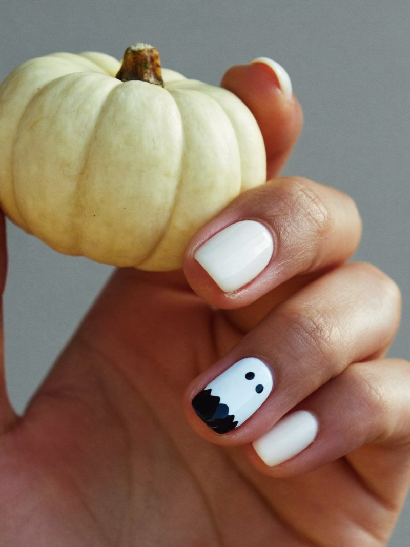 Short round milky white nails with one tiny ghost on the ring finger