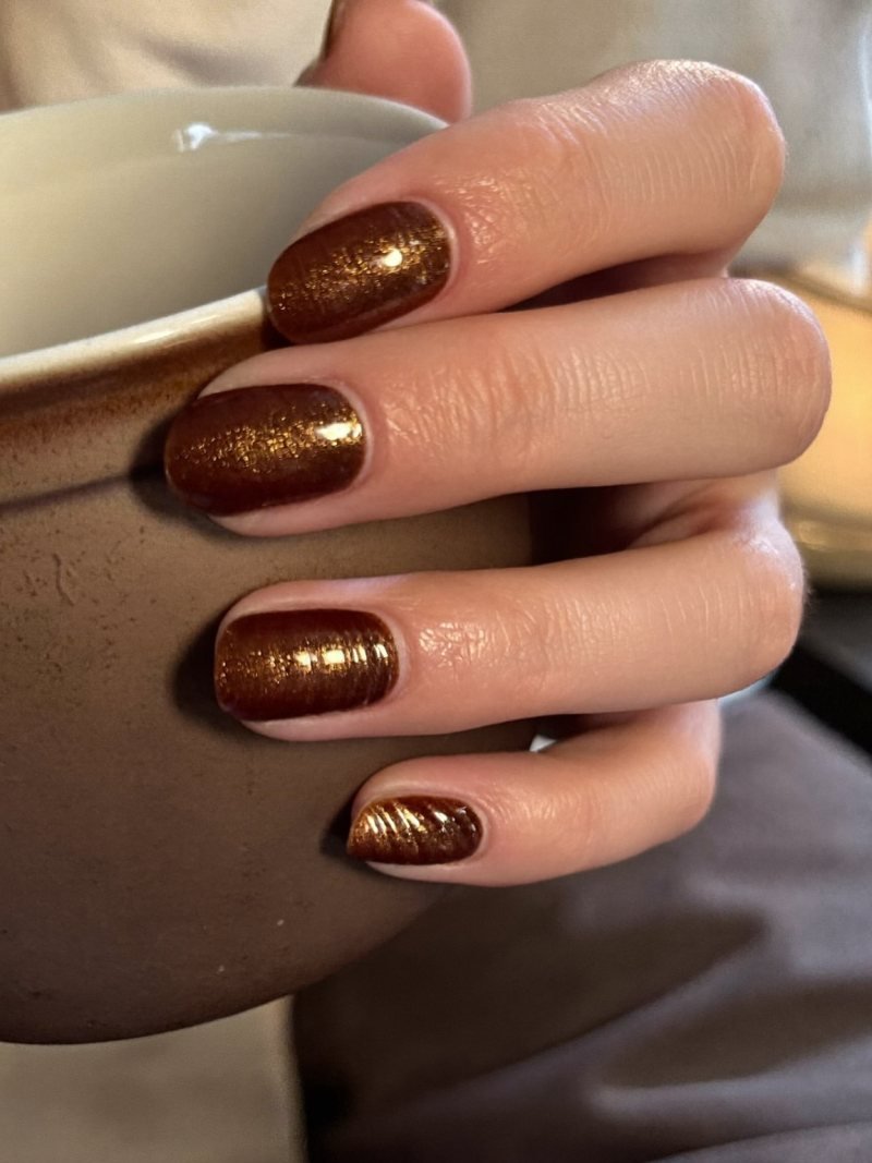Short round nails in espresso brown with fine gold shimmer
