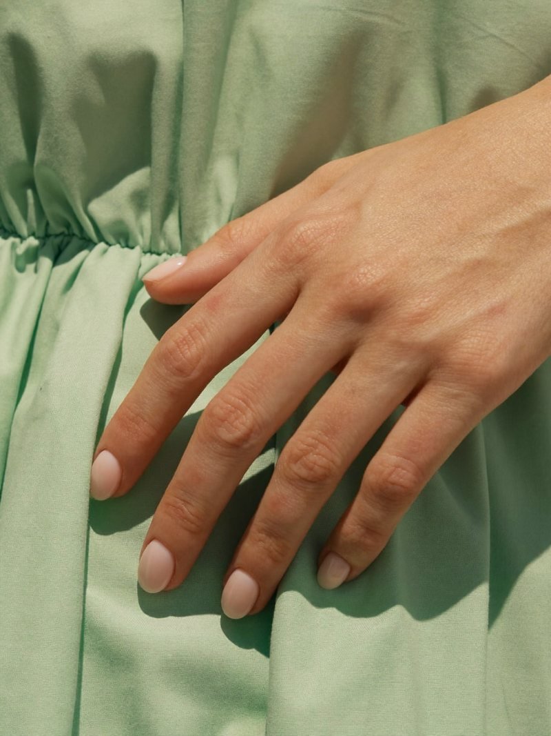 Short round sheer pink nails with a mint green dress