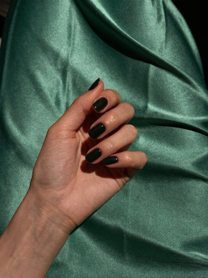 Short square black nails with an emerald dress