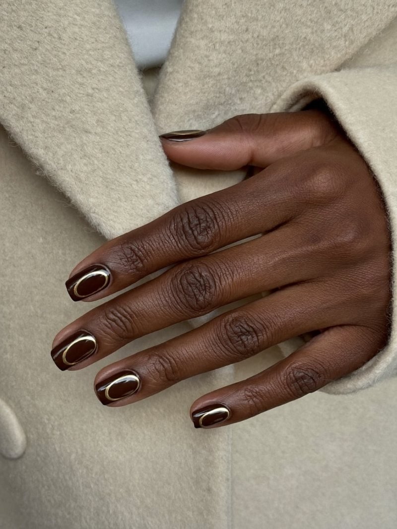 Short square chocolate brown nails with a fine gold line along the cuticle