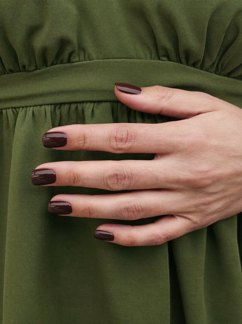 Short square chocolate brown nails with an olive dress