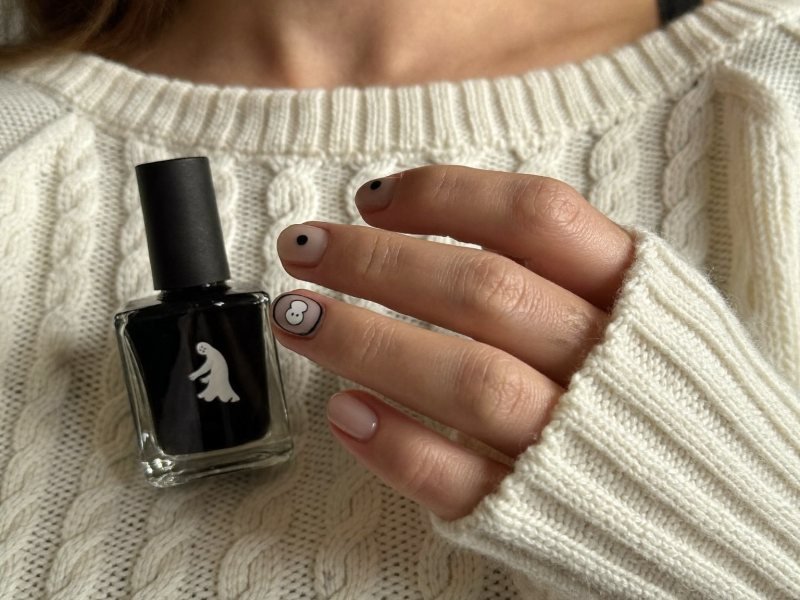 Simple Halloween nails on short round nails with black dots and one tiny ghost
