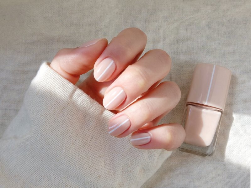 Simple nail designs: short nude nails with a single thin white line on each nail