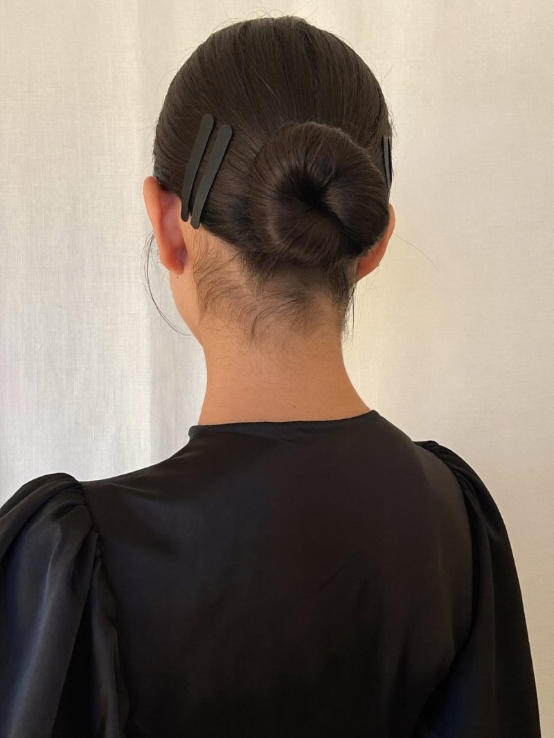 Sleek low bun decorated with small black hair clips
