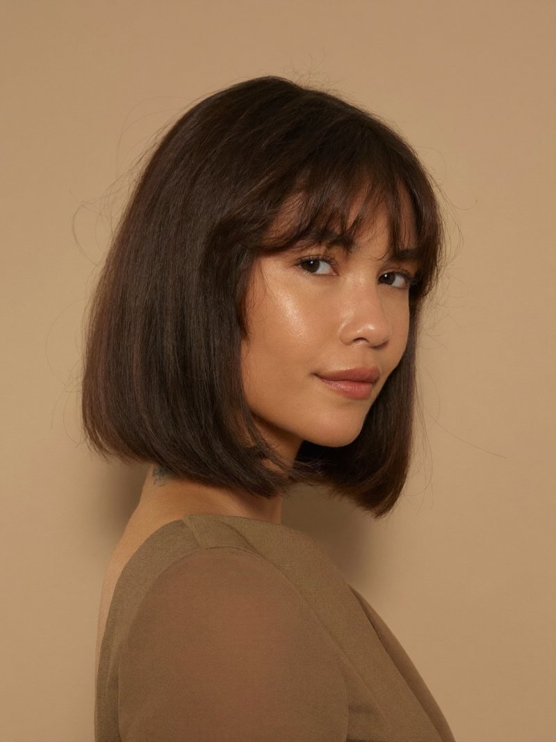 Woman with a chin length blunt French bob and soft bangs