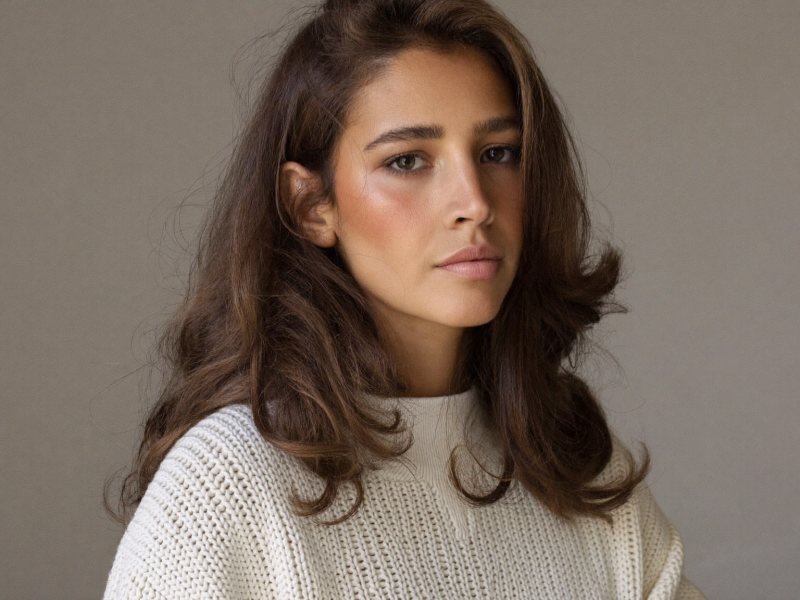 Woman with medium length layered haircuts styled in soft waves